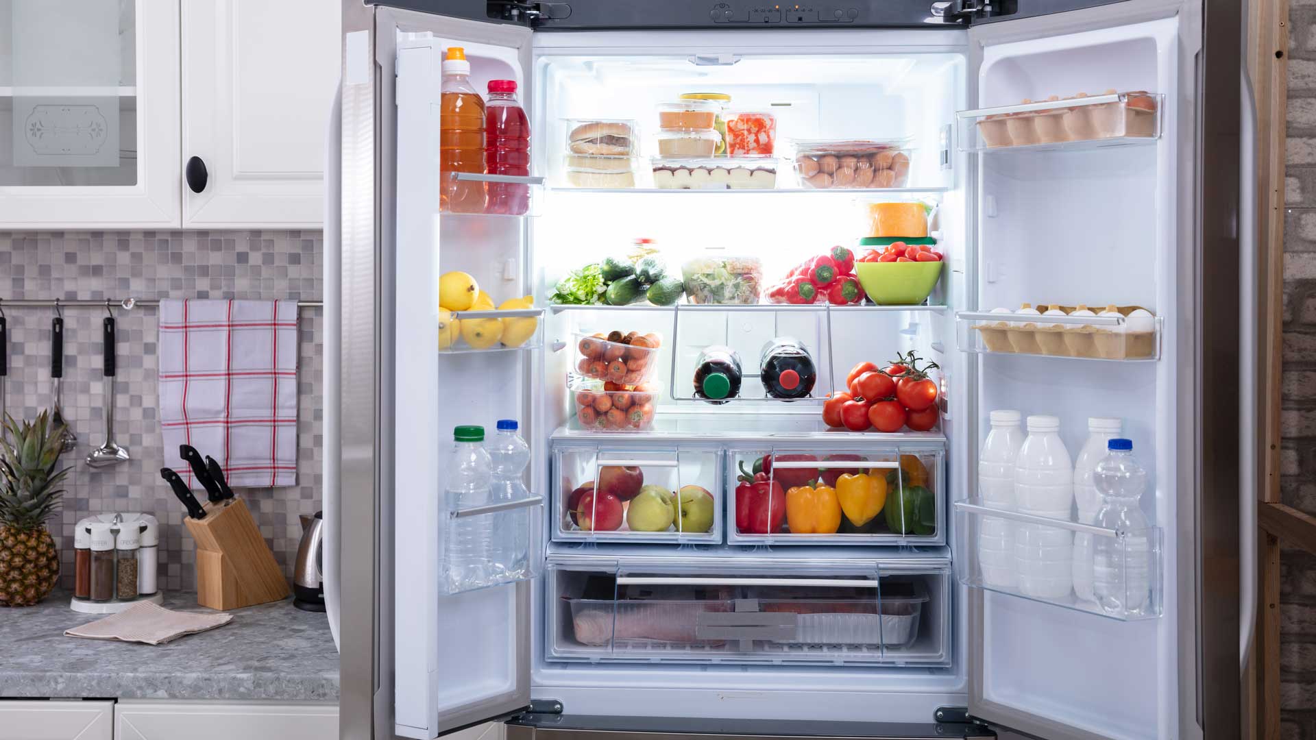 Open fridge, full of fresh fruits, vegetables, and eggs